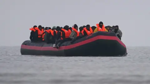 PA Media People thought to be migrants onboard a small boat in Gravelines, France.