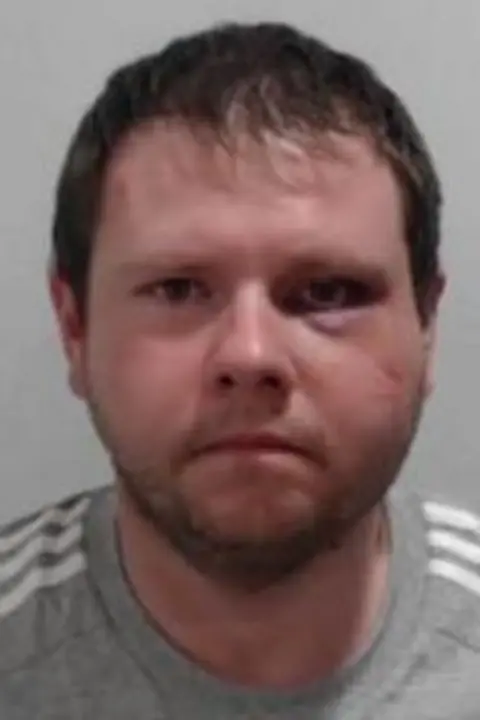 Police Scotland A mugshot of McAulay wearing a grey Adidas jumper 
