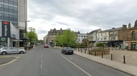 Google The same location as the digitally-drawn image. However, this is a photo of how it looks now. It looks almost the same, however the taxi rank area is much larger here, there is no cycle lane, the pavement on the left is about half as wide, and the pedestrian crossing appears less clear.