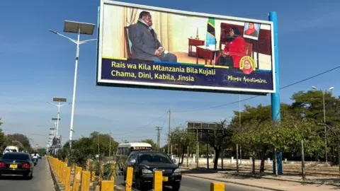 BBC/Alfred Rustek A billboard in Dodoma depicts President Samia Suluhu and her fiercest critic, Tundu Lissu.