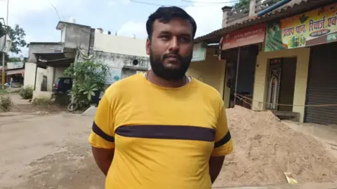 BBC Hindi Ajay Agarwal standing in front of village shops