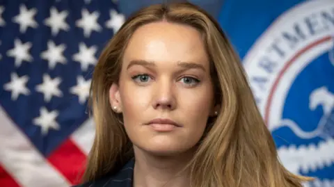 Tricia McLaughlin's official DHS portrait. She stands in front of a US flag