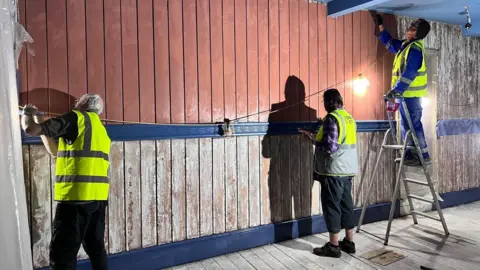 Morecambe Winter Gardens Three people in high vis jackets are carrying out repairs in the theatre.