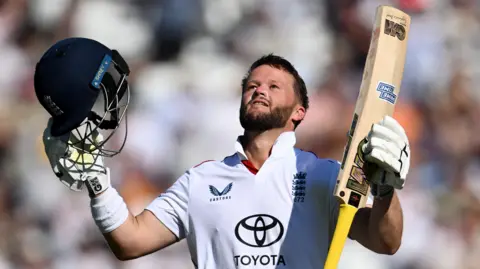 England opener Ben Duckett raises his helmet and bat to celebrate hitting a century