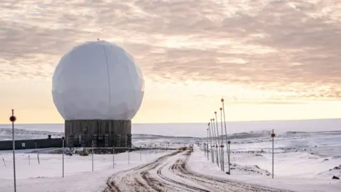 US Pituffik Space Base in northern Greenland against a pink sky