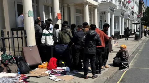 Rachael Burford/Evening Standard Asylum seekers outside hotel