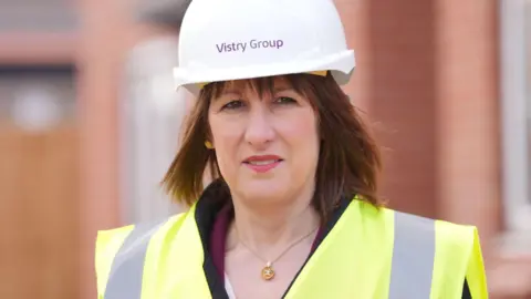 PA Media Rachel Reeves wearing a white hard hat and yellow high-vis jacket on a visit to a housing development site in Nottinghamshire