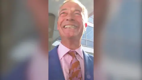 Nigel Farage wearing pale pink shirt and blue suit