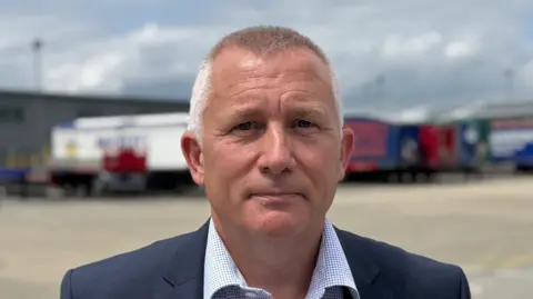 George King/BBC A head and shoulders image of Mark Ling - he is wearing a navy blazer over a smart shirt. He is looking directly into the camera