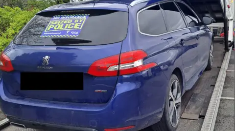 A seized car being loaded onto a low-loader