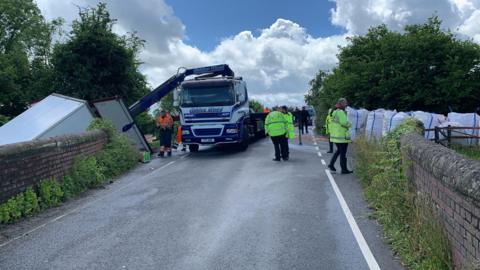 The scene of the crash including the lorry being removed from the canal