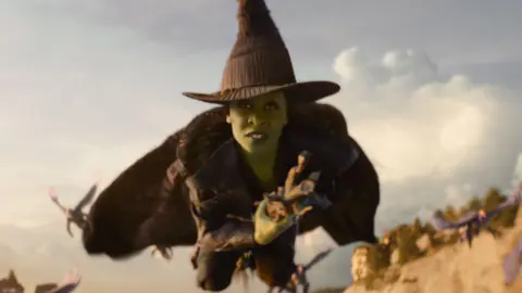 UNIVERSAL STUDIOS Cynthia Erivo has Elphaba in the upcoming Wicked: For Good movie. She is painted green and is flying on a broomstick.