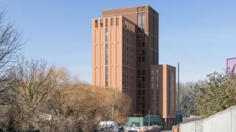 Smart Urban Living Bristol (One) A computer generated image shows a brown tower block by a road in an industrial area. 
