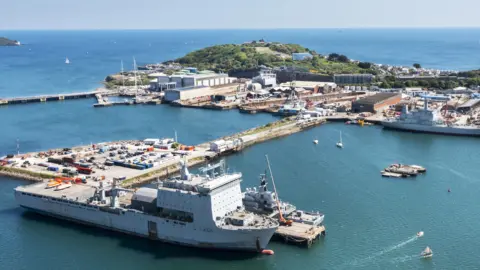 APCL A&P An aerial shot of Falmouth Docks looking out to sea with Pendennis Headland in the background and a large ship in the foreground docked up