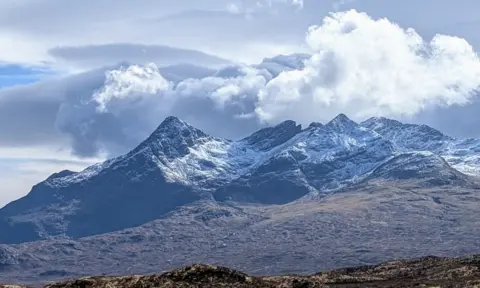 David Fowlie A mountain range with a light covering of snow 