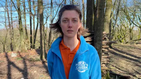 Harriet Saltis who has brown hair wearing a blue fleece jacket and orange polo shirt