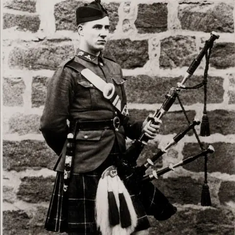Flett family Black and white photo of piper William Arnot Flett, wearing a kilt, with bagpipes.