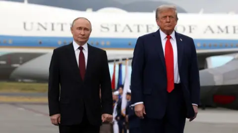 Trump and Putin pose for a photo on the airport tarmac before their meeting in Alaska. Air Force One is in the background.