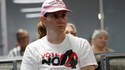 Reuters Ashley Urban, portant un t-shirt « Votez non » sur l'amendement 4 de Floride, qui aborde le projet de loi sur l'avortement de l'État, prie avec d'autres paroissiens 