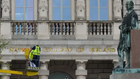 Getty Images Man on cherry picker wearing a high vis vest looking at the entrance to the national Gallery in Dublin 