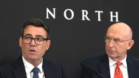 Andy Burnham and John Healey under a sign saying 10 North