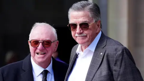 PA Media Dennis Taylor and Cliff Thorburn, two men with grey hair both wearing sunglasses, smiling for a photo outside Sheffield Cathedral.