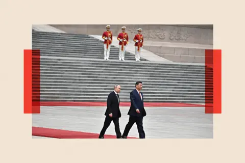 Getty  Vladimir Putin and Xi Jinping walk on a red carpet 