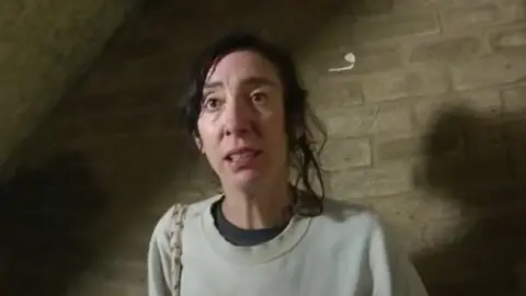 Kent Police Nina Mercer in a still from a video. She is wearing a beige jumper and has dark hair that is partly tied up.