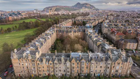Bird's eye view of tenements in Edinburgh. Arthur's Seat can be seen in the background. 
