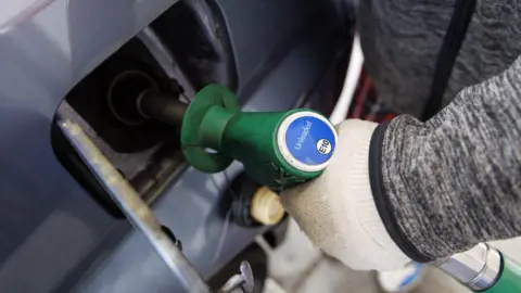 EPA/Shutterstock A gloved hand at an oil pump. 