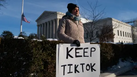 Woman holds "keep TikTok" poster 