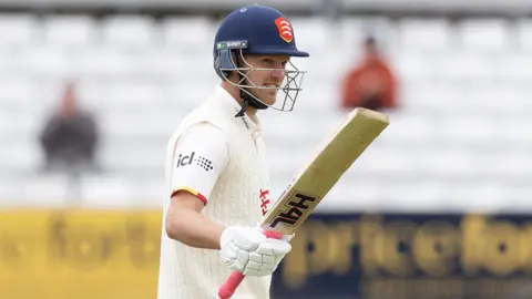 Jamie Porter raises his bat after reaching his first half-century in the County Championship