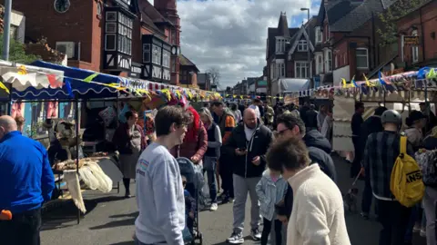 A road packed with people and market stalls