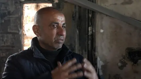Barhan Omar in his burnt house, in the Palestinian village of Deir al-Hatab, in the occupied West Bank