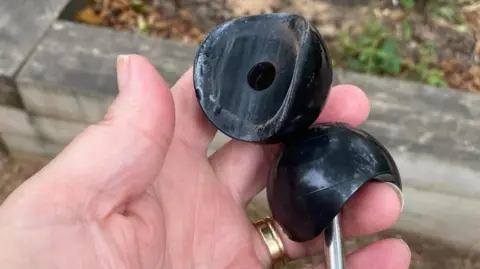 Kirsty Knight Two big black round bolts in Kirsty Knight's hand