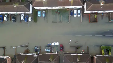 An aerial photograph of houses and homes surrounded by flood water