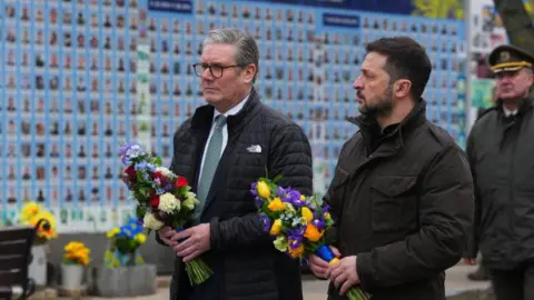 Getty Images Ukrainian President Volodymyr Zelensky lays flowers with Prime Minister Keir Starmer in Kyiv