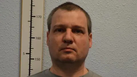 Metropolitan Police Met Police handout of Orlin Roussev, stood against a white background with a height measuring aid to his left