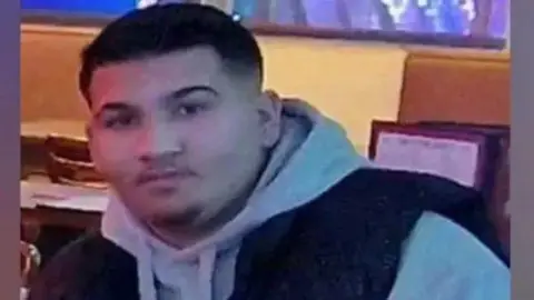 Family handout A teenage man with dark hair and stubble. He is wearing a grey hoodie and what appears to be a black gilet on top.