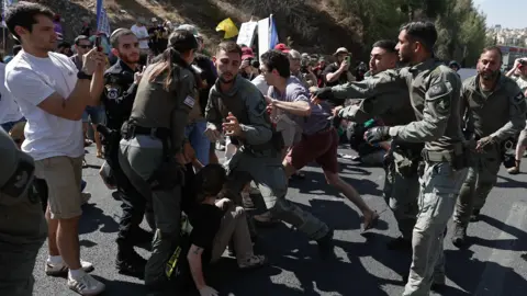 Palestinians flee IDF attacks on Gaza City as Israelis protest against occupation plan EPA Israeli protesters are dragged away while blocking a major highway amid nationwide strike in Jerusalem on 17 August 2025.