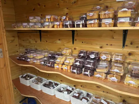 Shelves inside the Capel Cake Shed are filled with packaged cakes, brownies and traybakes.