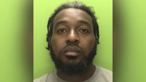 Nottinghamshire Police A police image showing a man with dreadlocks standing in front of a green background.