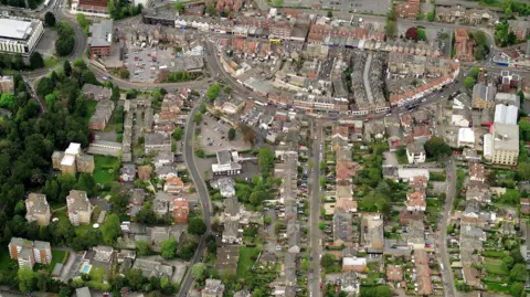 An aerial shot of Bournemouth showing buildings, roads and trees. 
