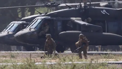 US Marines dressed in camouflage clothing and holding guns take part in training