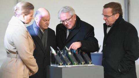 Danish Prime Minister Mette Frederiksen, CEO of Rheinmetall Armin Papperger, German Chancellor Olaf Scholz and German Defence Minister Boris Pistorius inspect ammunition as they visit the future site of an arms factory where weapons maker Rheinmetall plans to produce artilleries from 2025, in Unterluess, Germany February 12, 2024