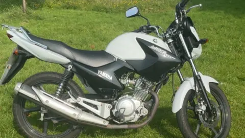 A photograph of the stolen Yamaha motorbike parked on grass