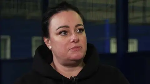 Close up of Sarah Bernasconi-Parsons. She has dark hair tied up and is wearing a black hoodie