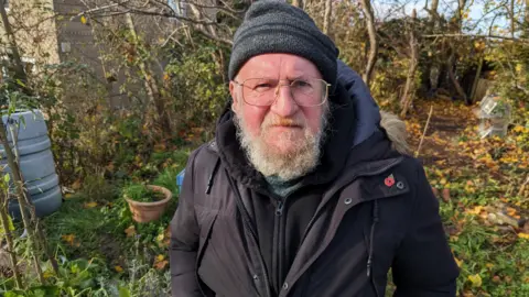 Pete Walker standing in the Lockleaze gardening project grounds