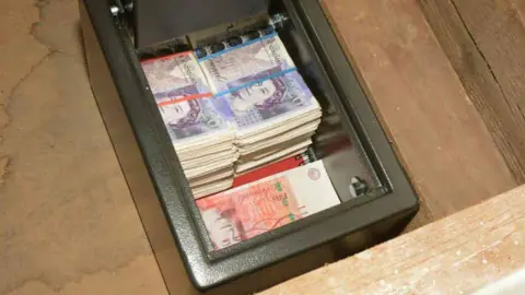 West Yorkshire Police A safe full of cash there are hundreds of £20 notes and £50 notes