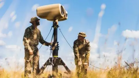 Instagram/Royal Air Force Regiment Two men in military khaki use a bit of kit that is on a stand